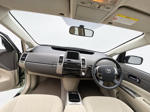Interior view of a Toyota vehicle with cream leather seats, steering wheel, dashboard, and panoramic sunroof