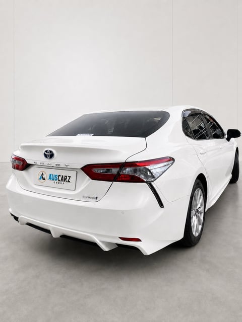 White Toyota Camry sedan from rear angle with sunshade displayed on windshield