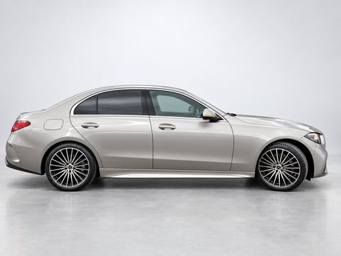 Silver sedan car photographed from the side profile against a light gray background