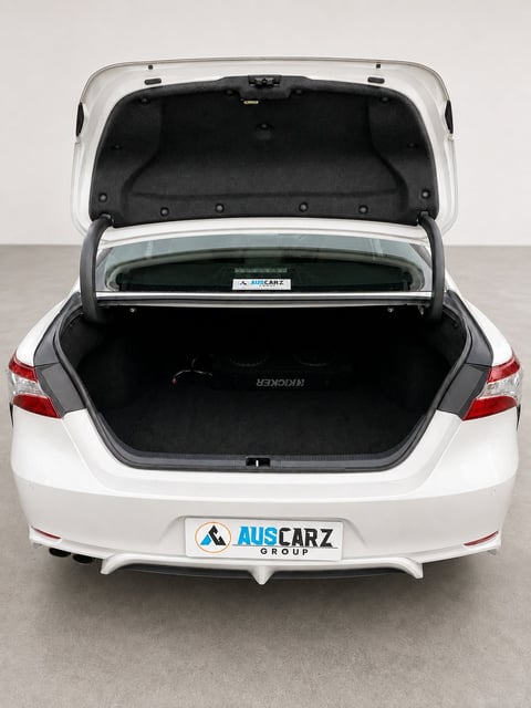 White sedan with open trunk showing empty cargo space, AusCarz Group license plate visible