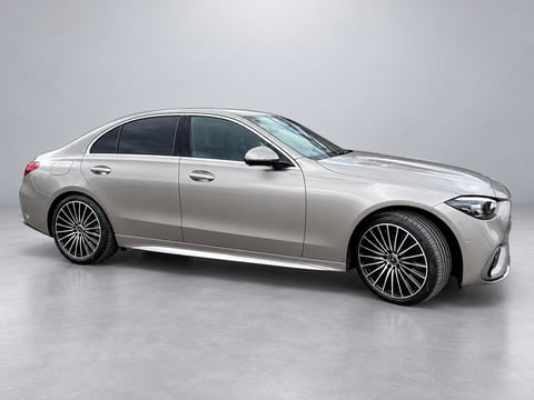 Silver luxury sedan with distinctive grille design and multi-spoke alloy wheels, photographed against a neutral gray background