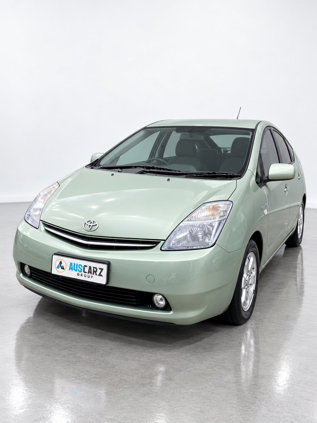 Light green Toyota Prius hybrid car photographed from front-left angle in studio setting