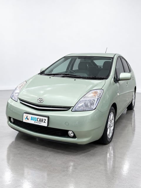 Light green Toyota Prius hybrid car photographed from front-left angle in studio setting