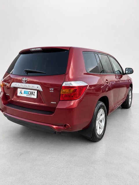 Red Toyota Kluger SUV photographed from the rear three-quarter angle against a white background