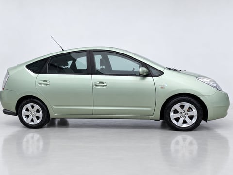 Side view of a light green Toyota Prius hybrid car with white alloy wheels on white background
