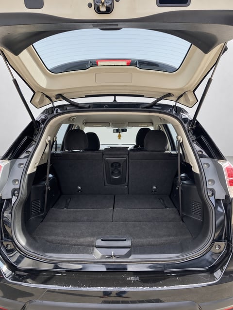 Open boot of the black Nissan X-Trail T32 SUV showing the empty cargo area with beige trim