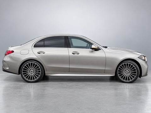 Silver luxury sedan with multi-spoke wheels photographed from side profile against gray background