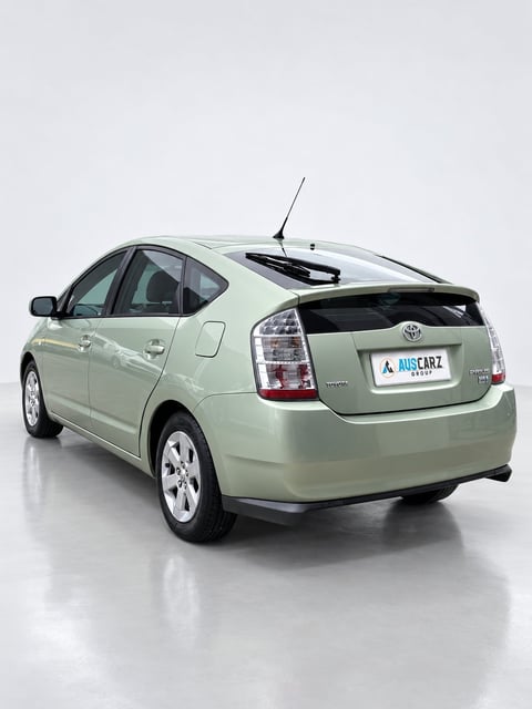 Light green Toyota Prius hybrid car photographed from the rear three-quarter view against a white background