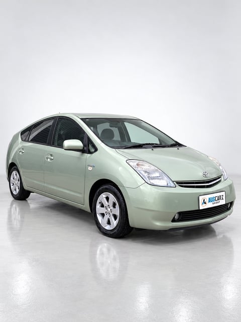 Light green Toyota Prius hybrid car photographed from the side angle on white background with reflection