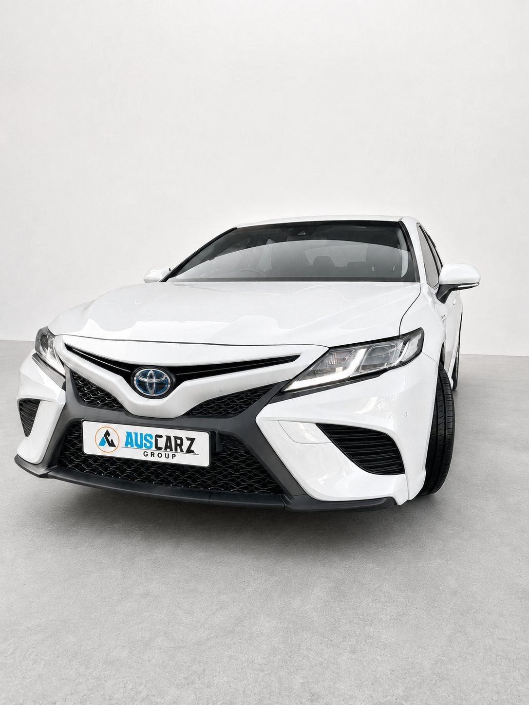 White Toyota Camry sedan front three-quarter view
