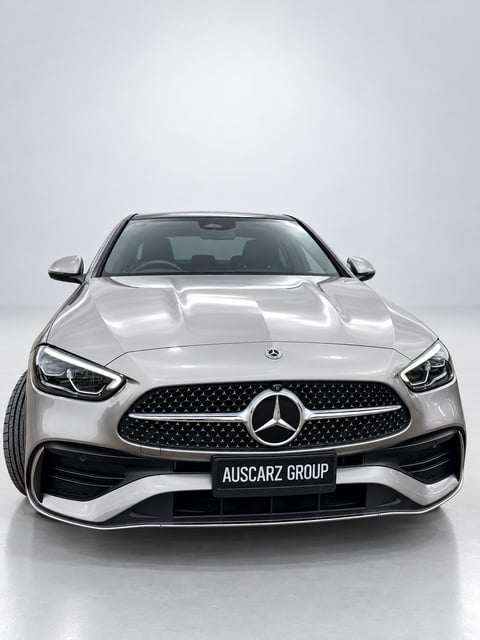 Silver Mercedes-Benz C-Class sedan viewed from front, displaying distinctive grille and headlights on neutral background